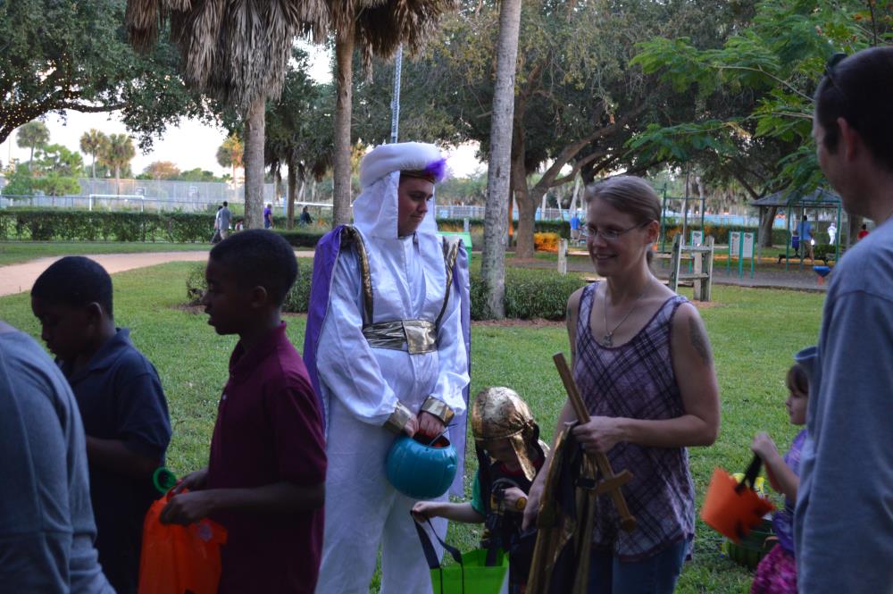 Person dressed as a sultan holding blue jack-o-lantern candy bucket